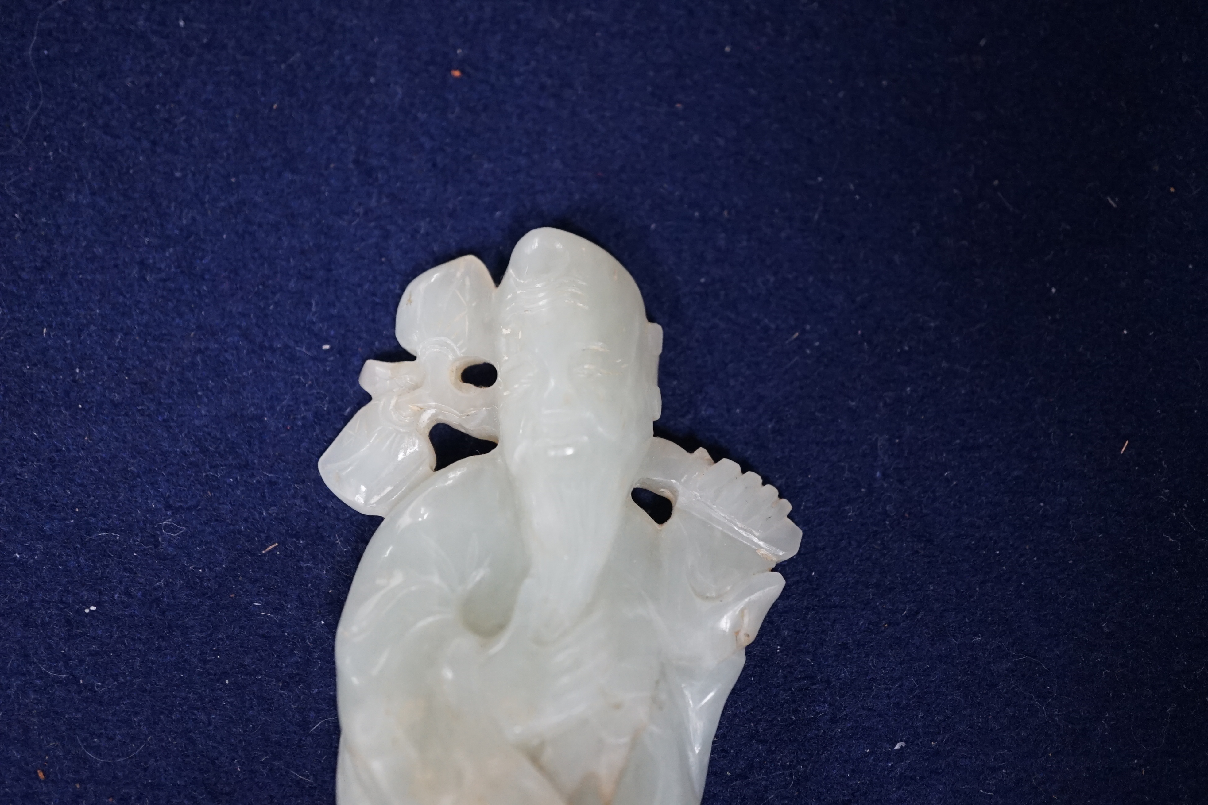 A Chinese pale celadon jade figure of Shou Lao, wood stand, 10cm high